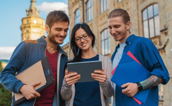 a-group-of-young-multi-ethnic-group-of-student-in-university-smiling-and-looking-at-the-tablet.jpg